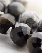 Vista de varias pulseras en tonos negro, gris y blanco sobre superficie de mármol