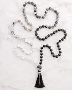 Japa Mala Dualidad extendido junto a sus pulseras a juego sobre superficie de mármol