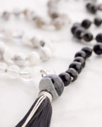 Pulseras del Japa Mala Dualidad en tonos blanco, gris y negro sobre mármol