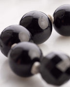 Detalle macro de cuentas facetadas de Obsidiana Negra de gran tamano