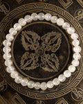 Pulsera de Selenita, pieza completa en círculo sobre bandeja grabada