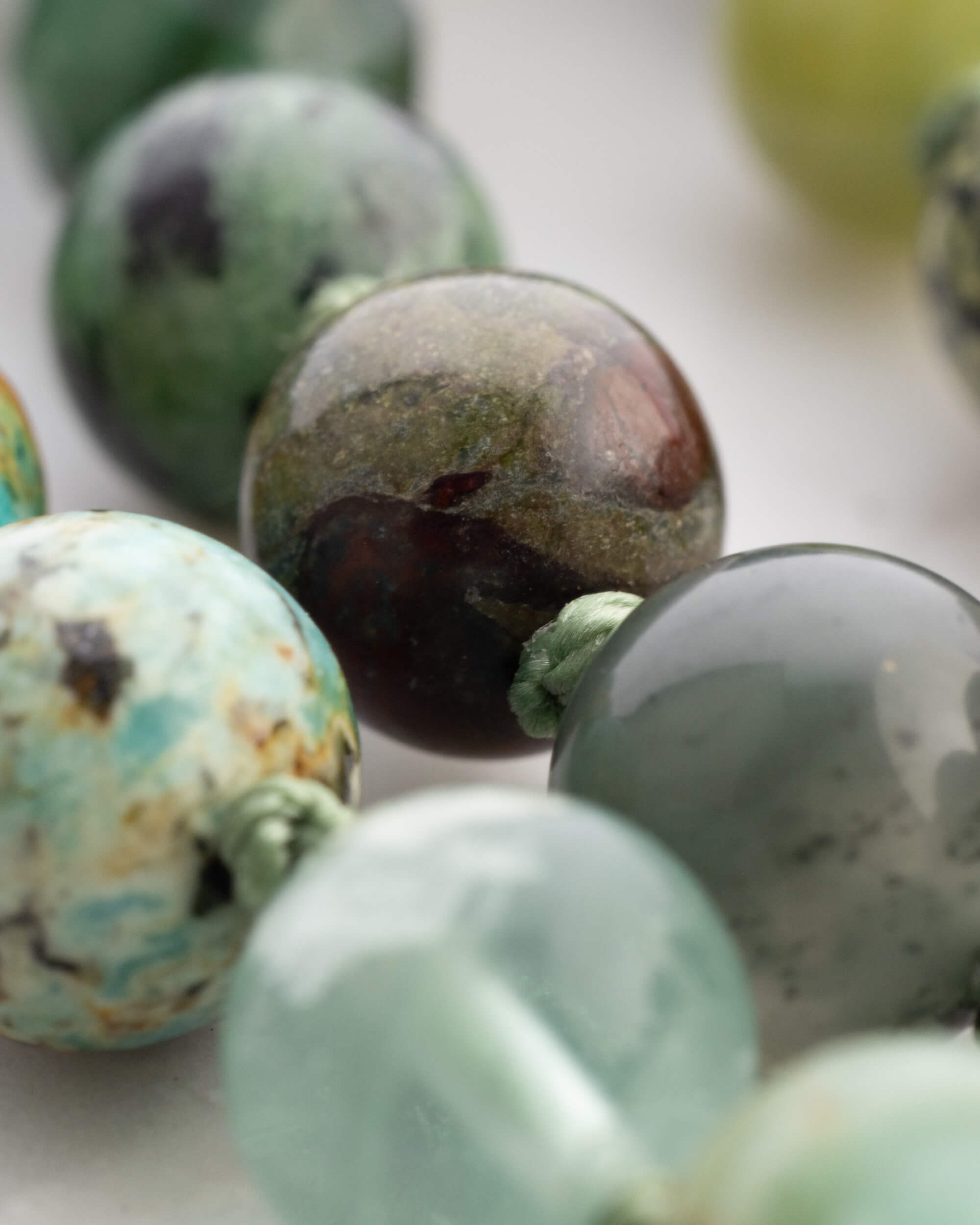 Detalle macro de cuentas de Granate Verde, Jaspe Sangre de Dragon y Jade