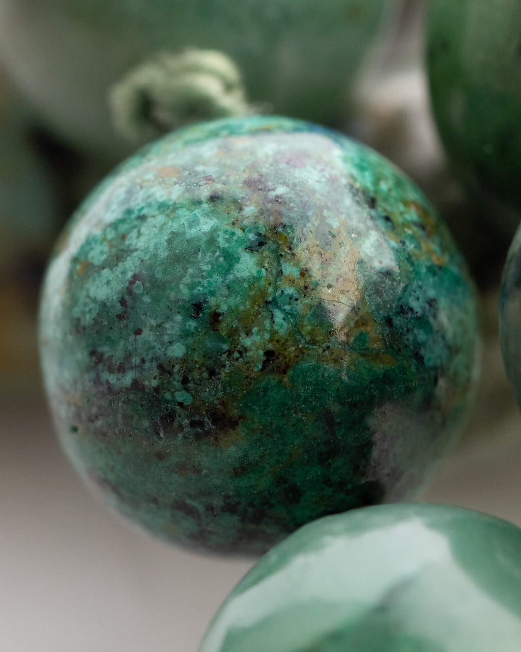 Detalle macro de una cuenta verde oscura con manchas negras del Japa Mala Corazon