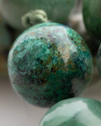 Detalle macro de una cuenta verde oscura con manchas negras del Japa Mala Corazon