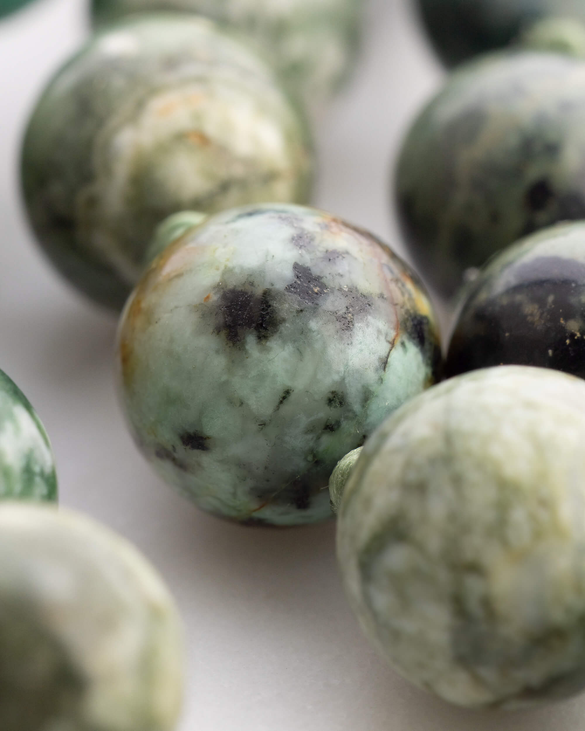 Detalle macro de una cuenta facetada de Jade Verde entre Ágata y Turquesa Africana