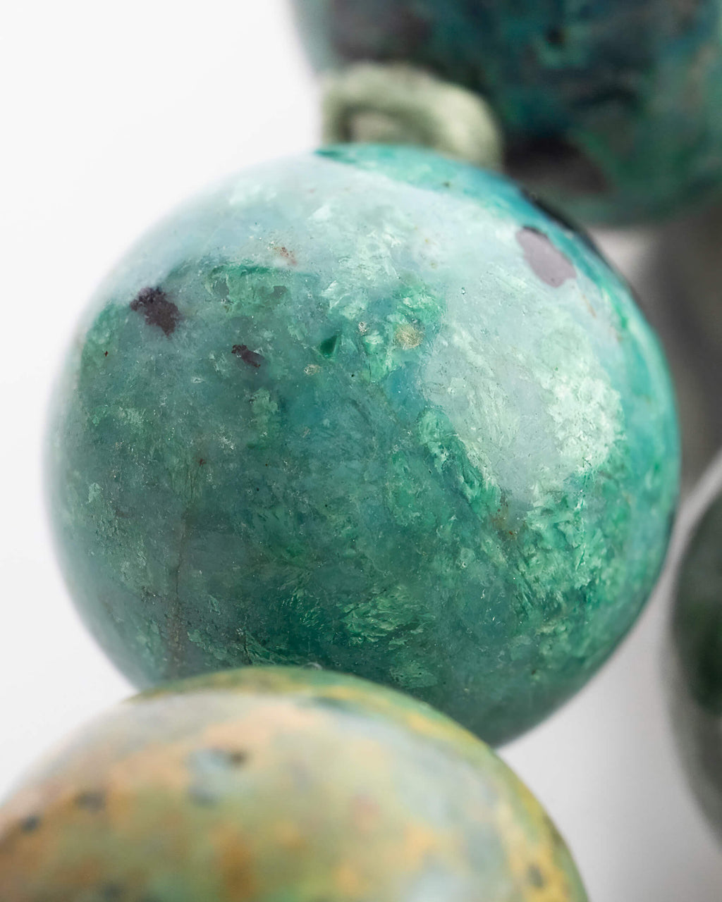 Detalle macro de una cuenta de Turquesa Africana con vetas cafes y azules