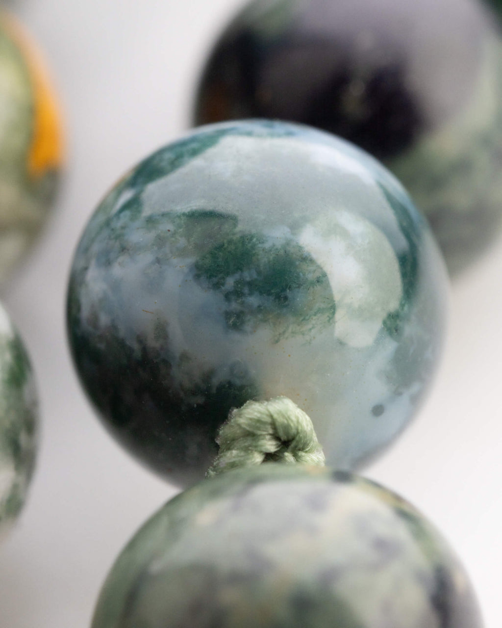 Detalle macro de cuentas de Jade Verde y Ágata Musgosa en primer plano