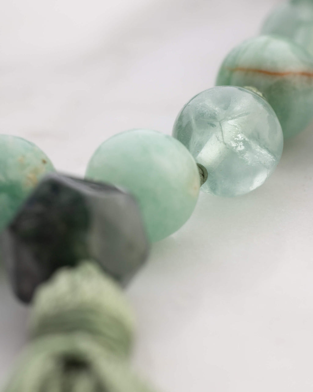 Japa Mala Corazon puesto en el cuello, cuentas verdes con tonos coral