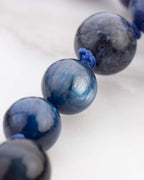 Detalle macro de cuentas redondas azules con brillo aperlado y vetas grisaceas del Japa Mala Universo
