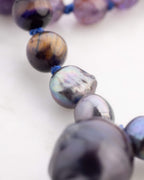 Detalle macro de una perla barroca junto a Ojo de Tigre del Japa Mala Universo