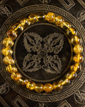 Pulsera de Ámbar en círculo sobre plato metálico grabado con motivo oriental