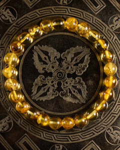 Pulsera de Ámbar en círculo sobre plato metálico grabado con motivo oriental