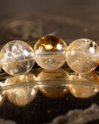 Detalle macro de las cuentas doradas de Citrino con reflejo dorado