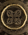 Pulsera de Cuarzo Rutilado de 4 mm, pieza completa sobre disco decorativo oscuro