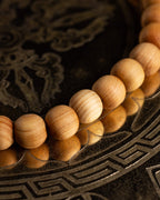Pulsera de Madera de Sándalo en ángulo diagonal sobre bandeja grabada