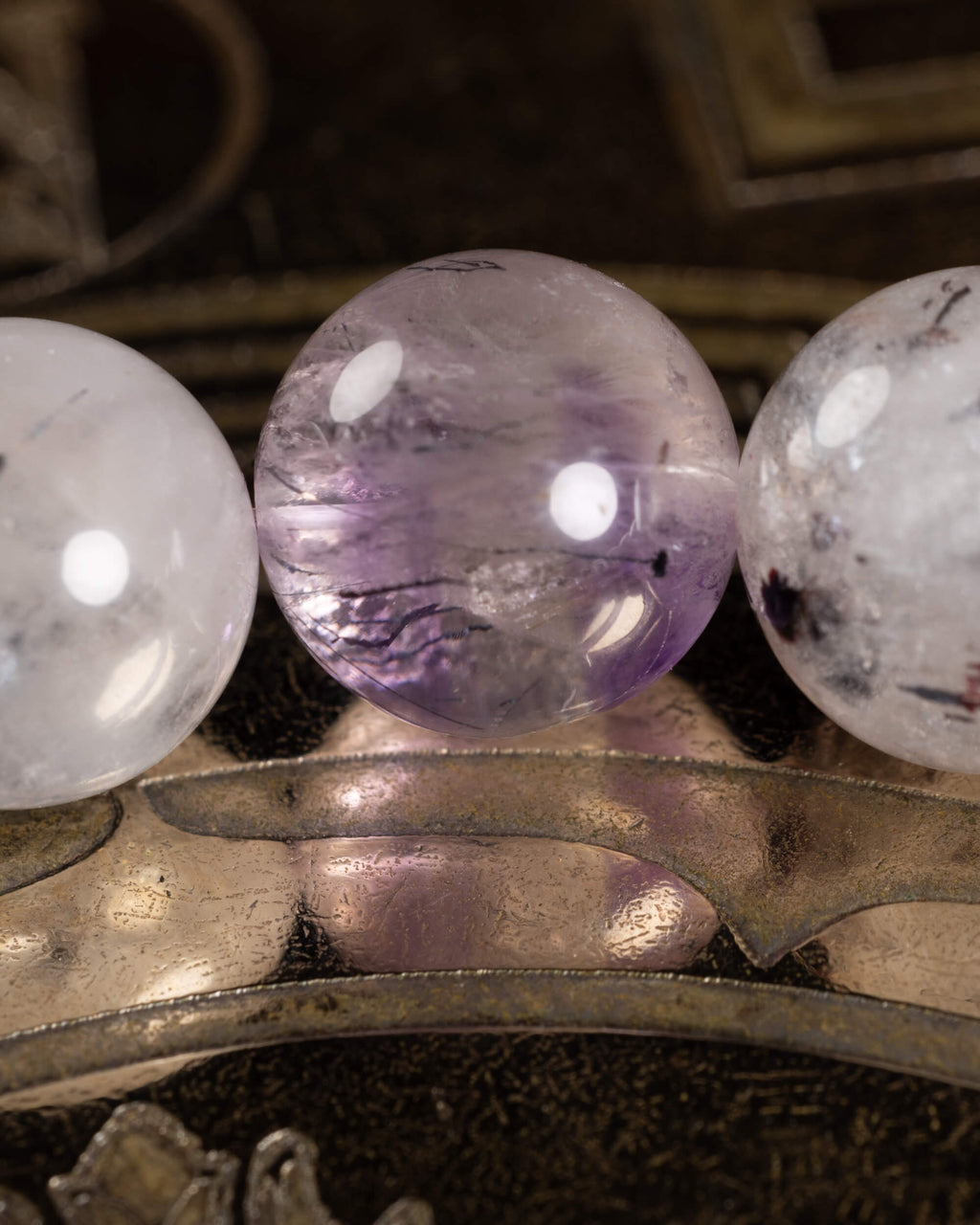 Detalle macro de tres cuentas de Super 7, una en tono lila con vetas oscuras