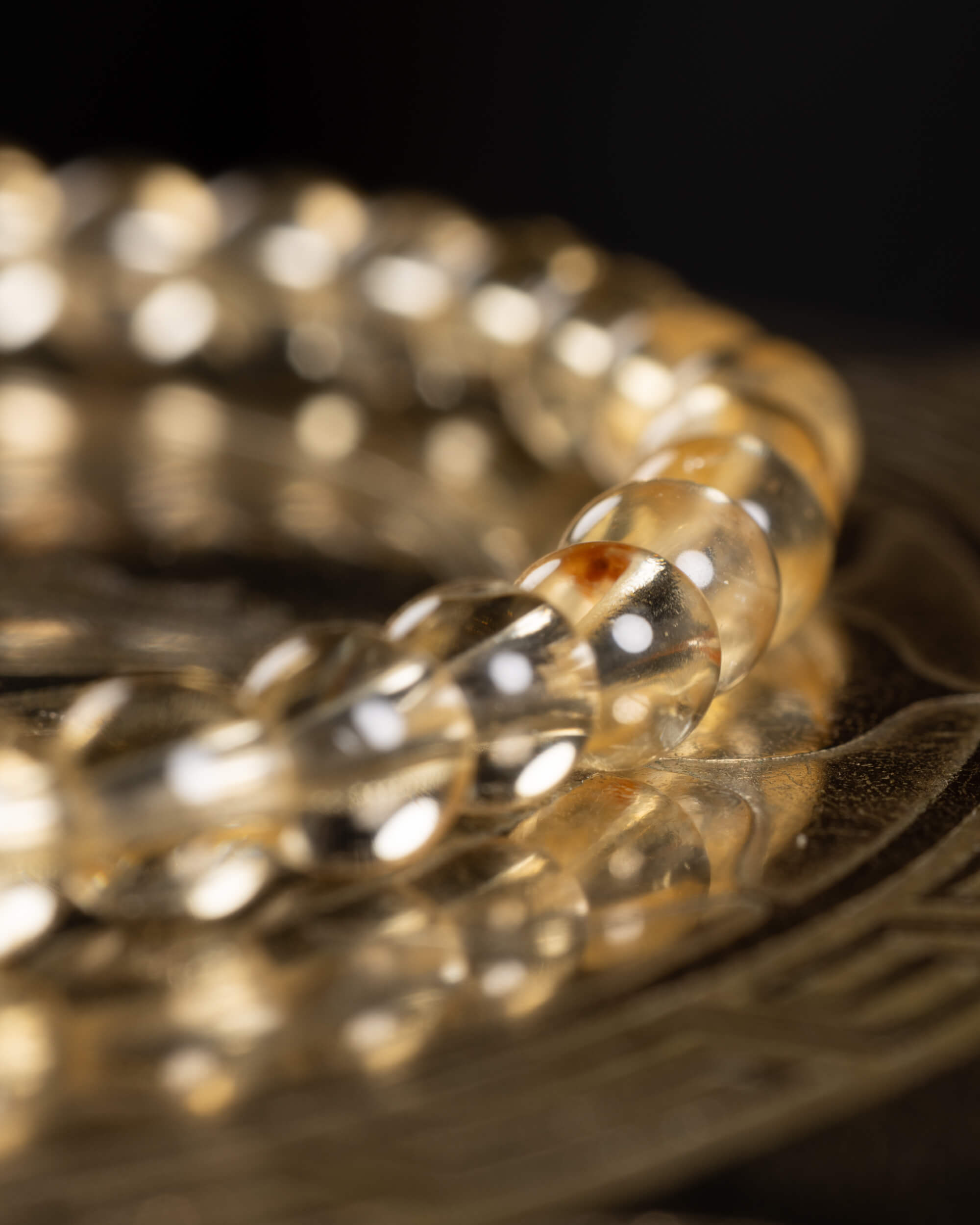 Pulsera de Citrino vista en angulo sobre soporte metálico grabado