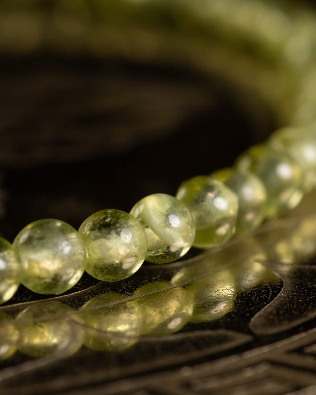 Pulsera de Peridoto en angulo cerrado, cuentas verdes sobre soporte grabado
