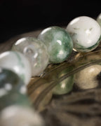 Detalle macro de las cuentas de Ágata Arbol en degradado blanco y verde musgo