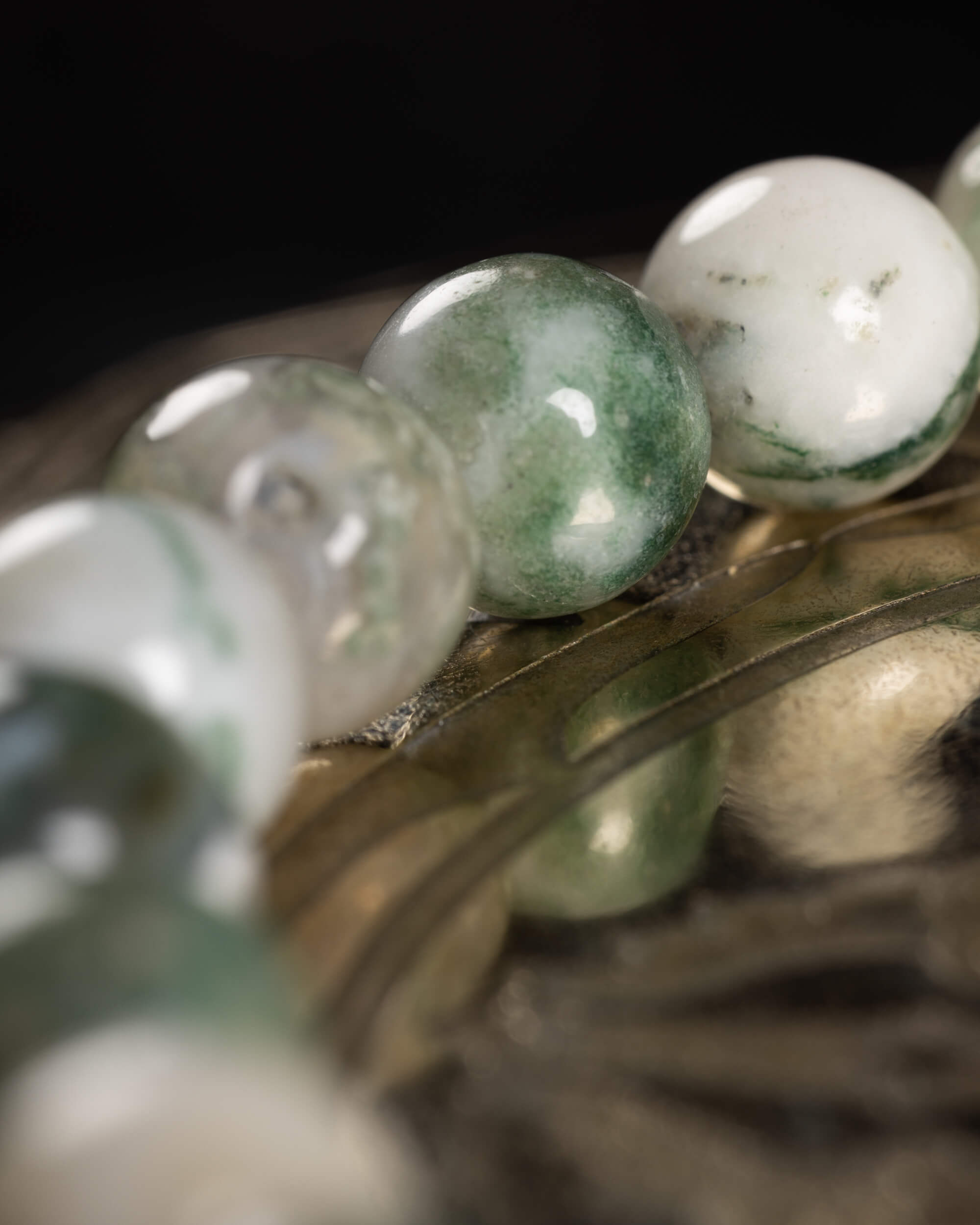 Detalle macro de las cuentas de Ágata Arbol en degradado blanco y verde musgo