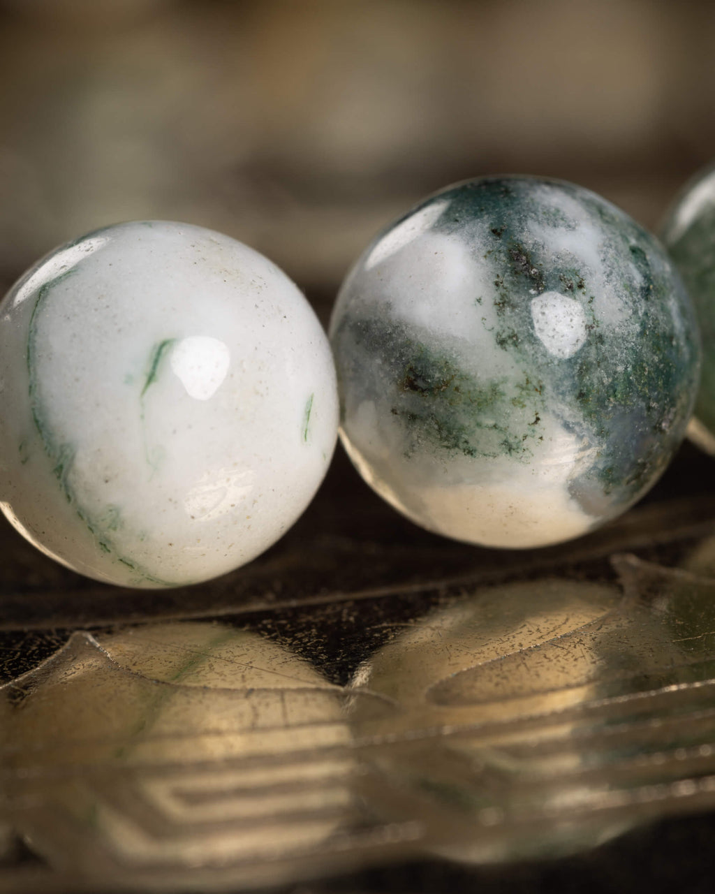 Detalle macro de dos cuentas de Ágata Arbol, blanca y con vetas verdes