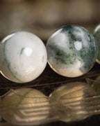 Detalle macro de dos cuentas de Ágata Arbol, blanca y con vetas verdes