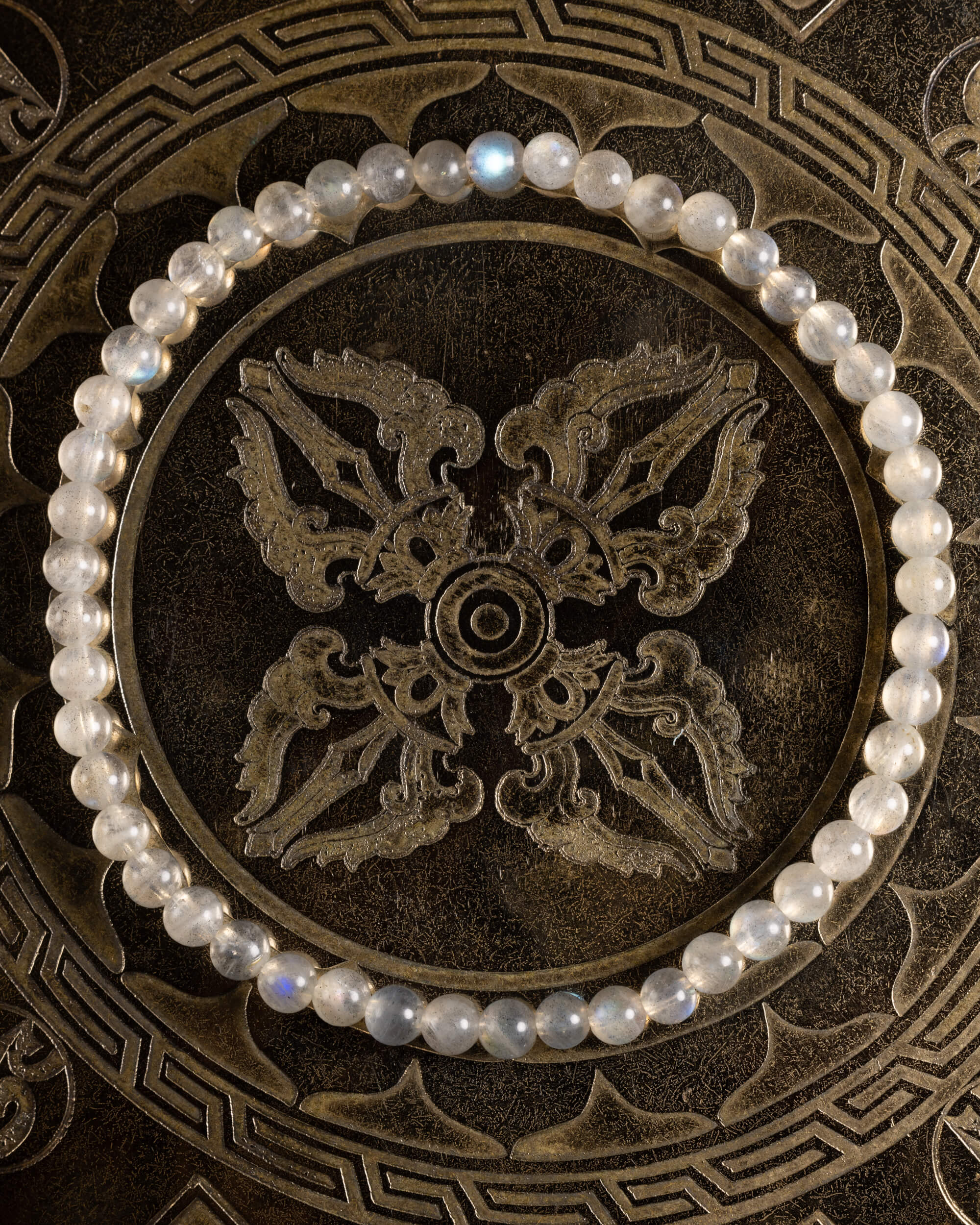 Pulsera de Labradorita, pieza completa en círculo sobre bandeja tallada de bronce