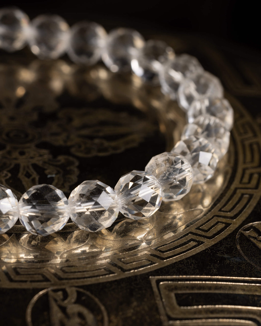 Pulsera de Cuarzo Transparente facetada, vista en perspectiva sobre soporte con grabado circular