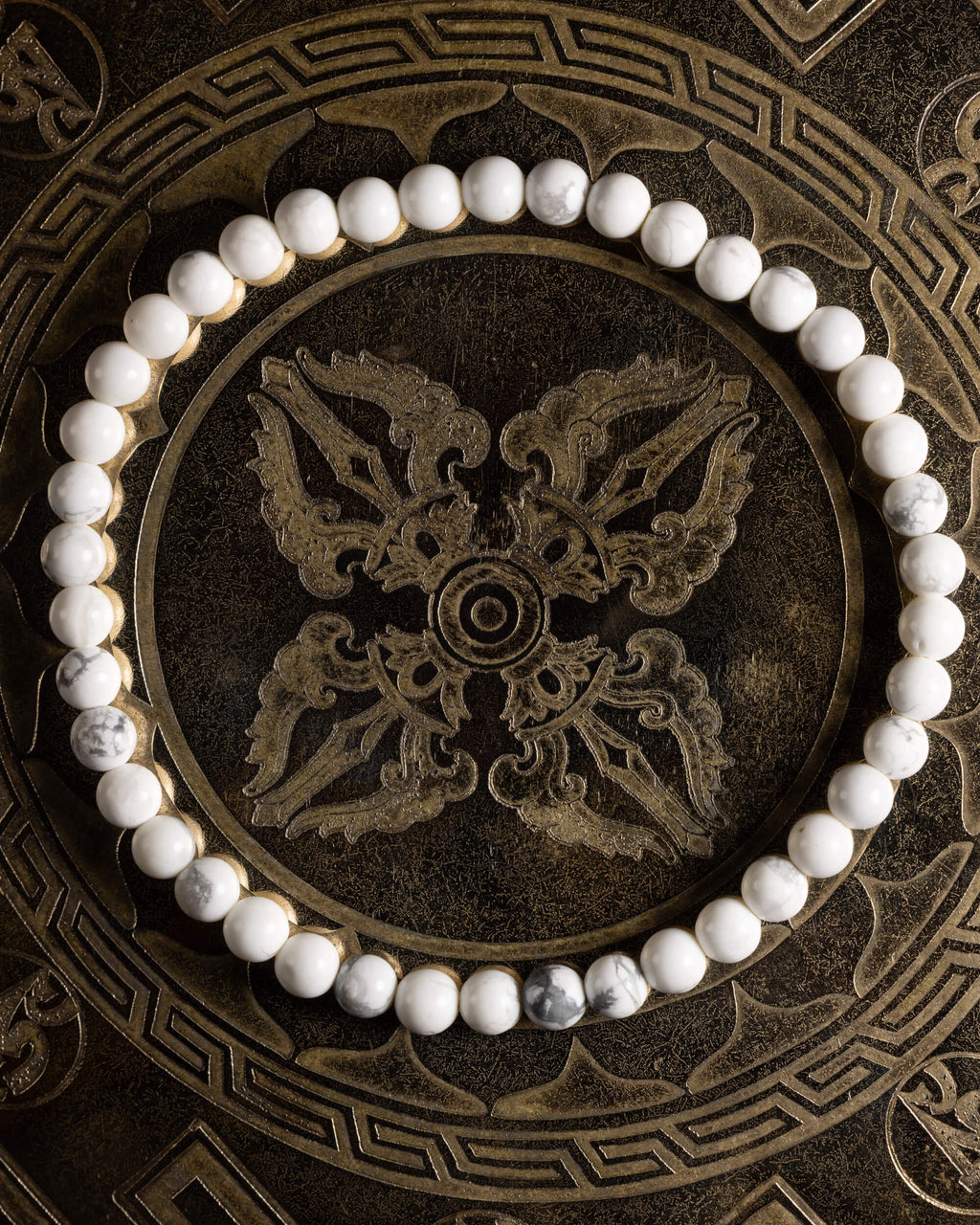 Pulsera de Howlita completa, en círculo sobre bandeja labrada oscura