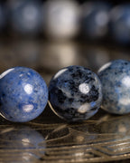 Detalle macro de tres cuentas de Dumortierita en distintos tonos de azul