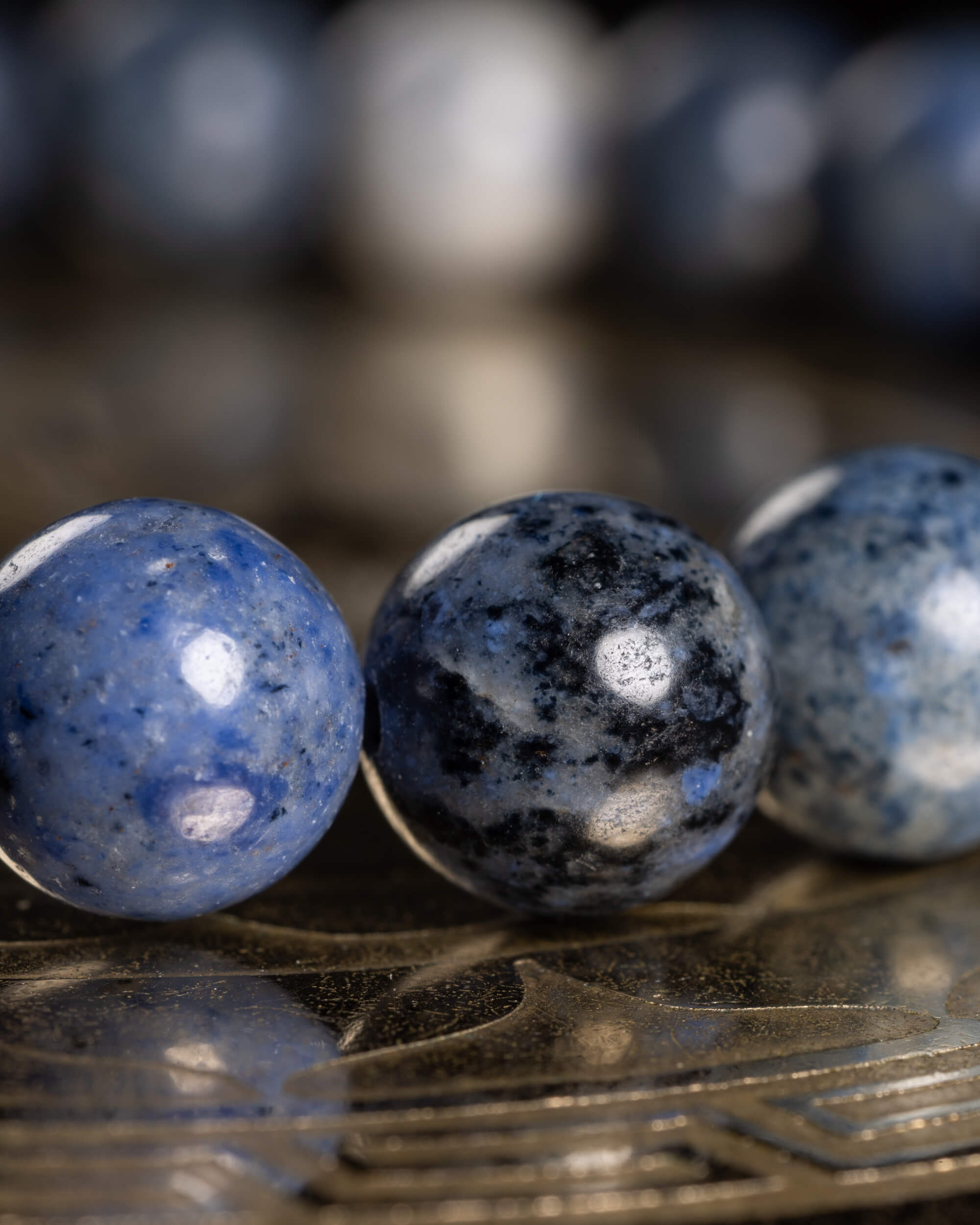 Detalle macro de tres cuentas de Dumortierita en distintos tonos de azul