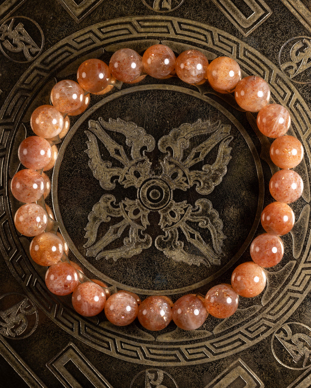 Pulsera de Piedra Sol Roja de 8 mm, pieza completa sobre disco grabado oscuro