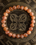 Pulsera de Piedra Sol Roja de 8 mm, pieza completa sobre disco grabado oscuro
