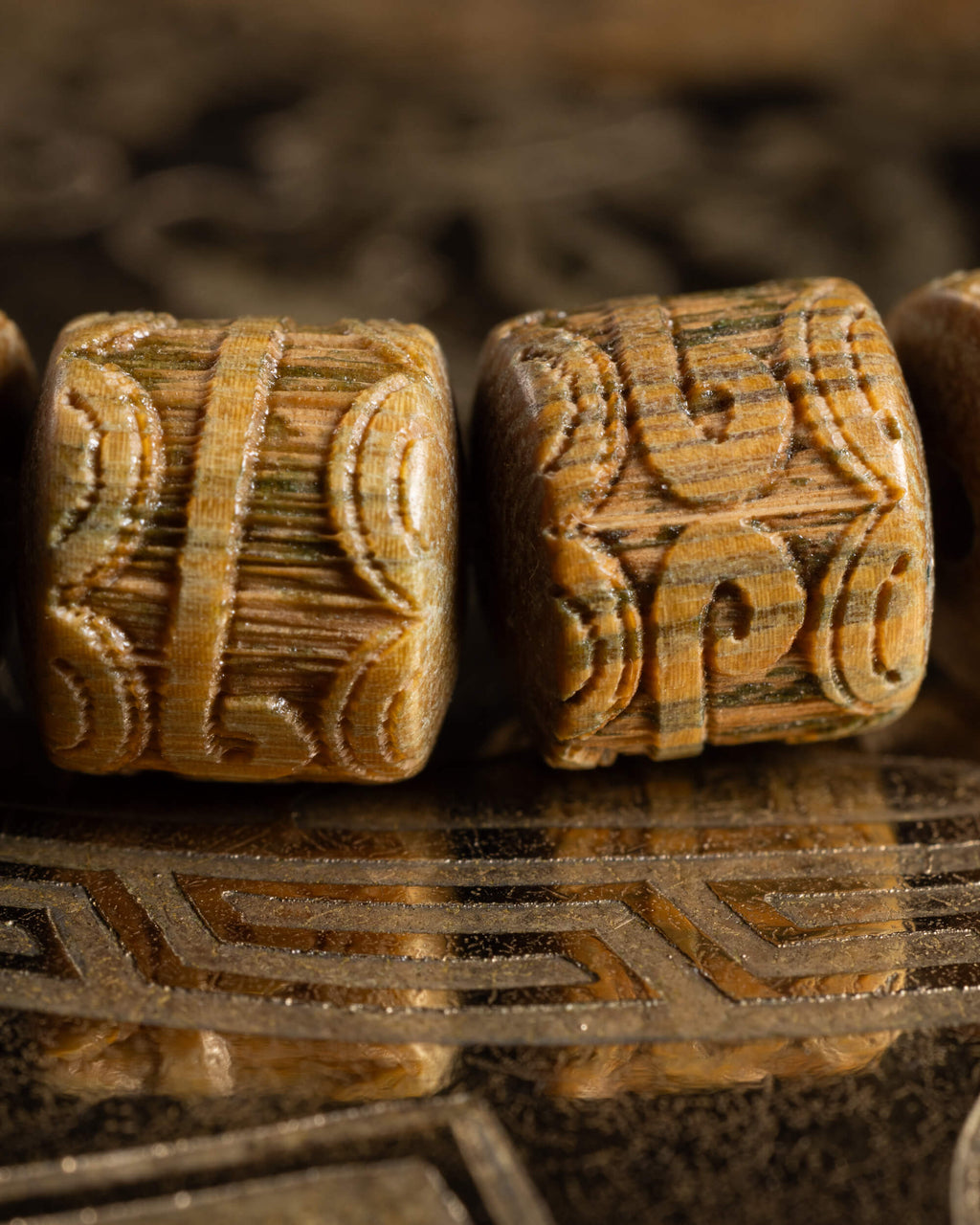 Detalle macro de dos cuentas cilíndricas talladas de Madera de Sándalo