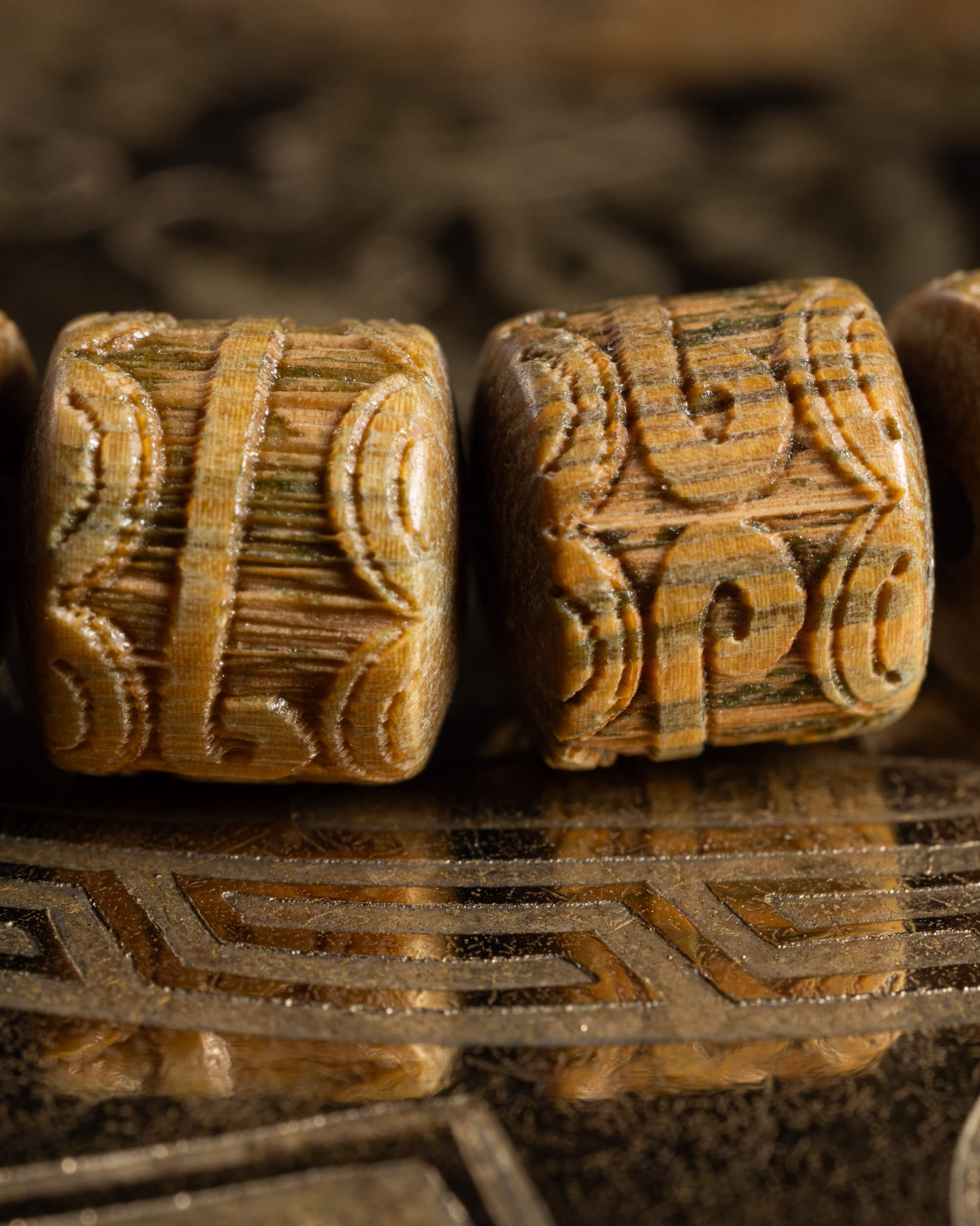 Detalle macro de dos cuentas cilíndricas talladas de Madera de Sándalo