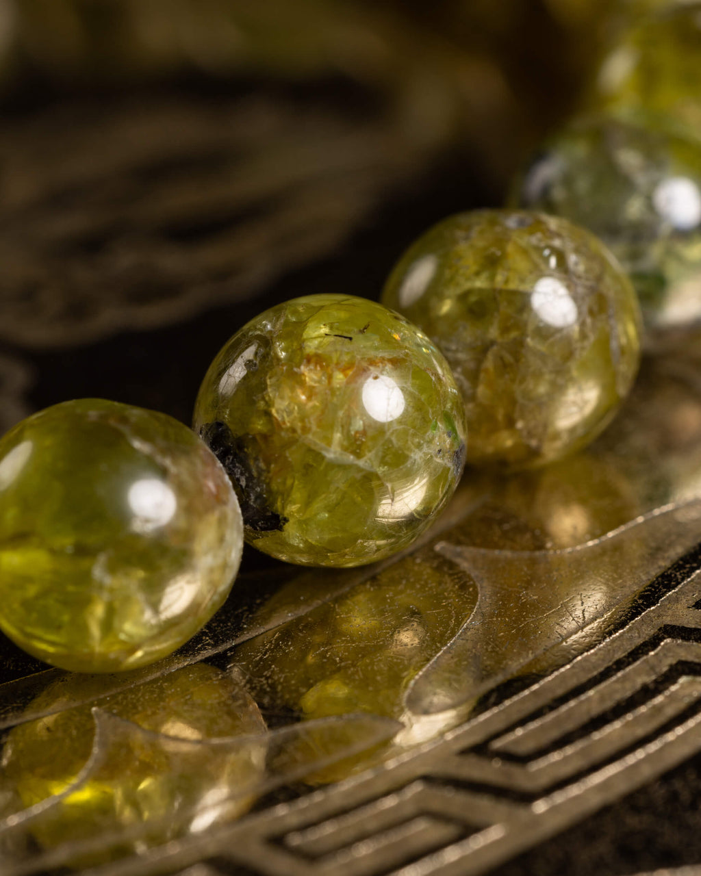 Detalle macro de las cuentas de Peridoto con inclusiones y brillo natural