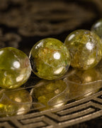 Detalle macro de las cuentas facetadas de Peridoto con brillo verde amarillento