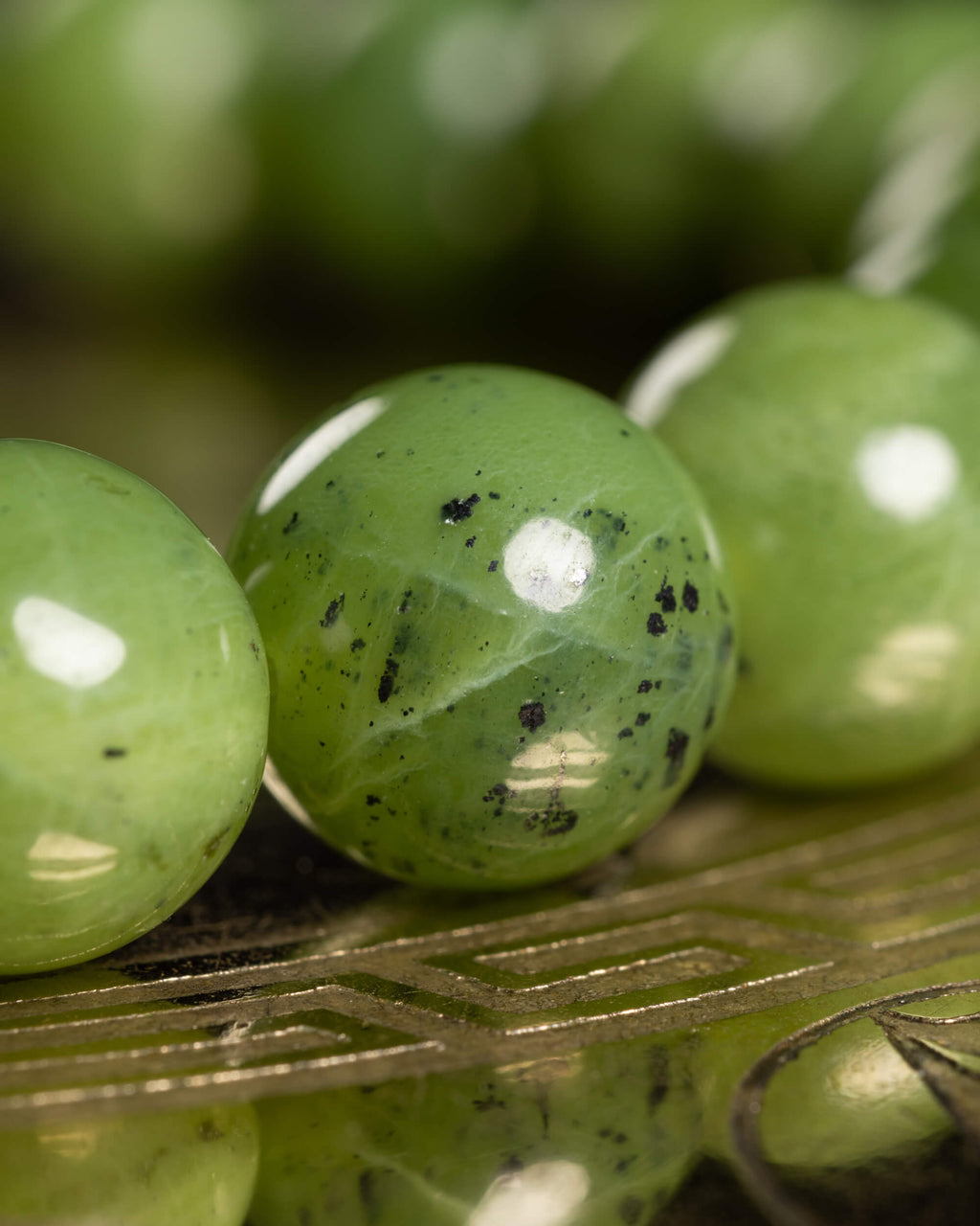 Detalle macro de las cuentas de Jade Verde con vetas oscuras naturales