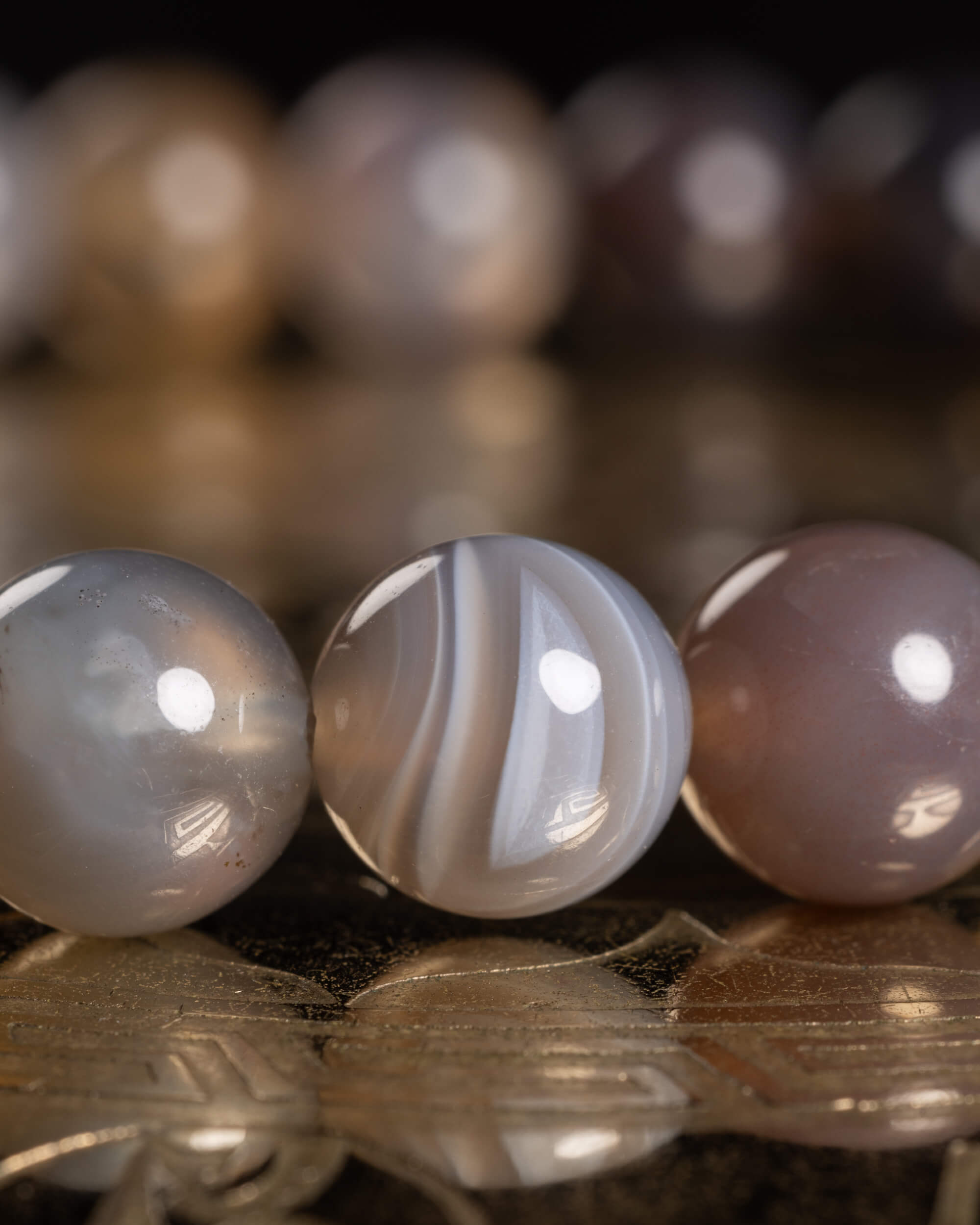 Detalle macro de las cuentas de Ágata Botsuana en tonos gris y café