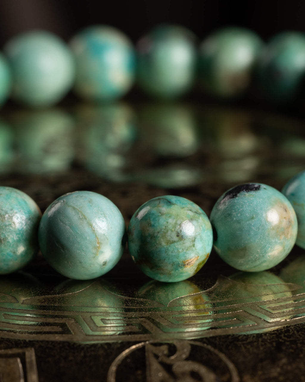 Pulsera de Turquesa Peruana en perspectiva, curva de cuentas sobre soporte grabado