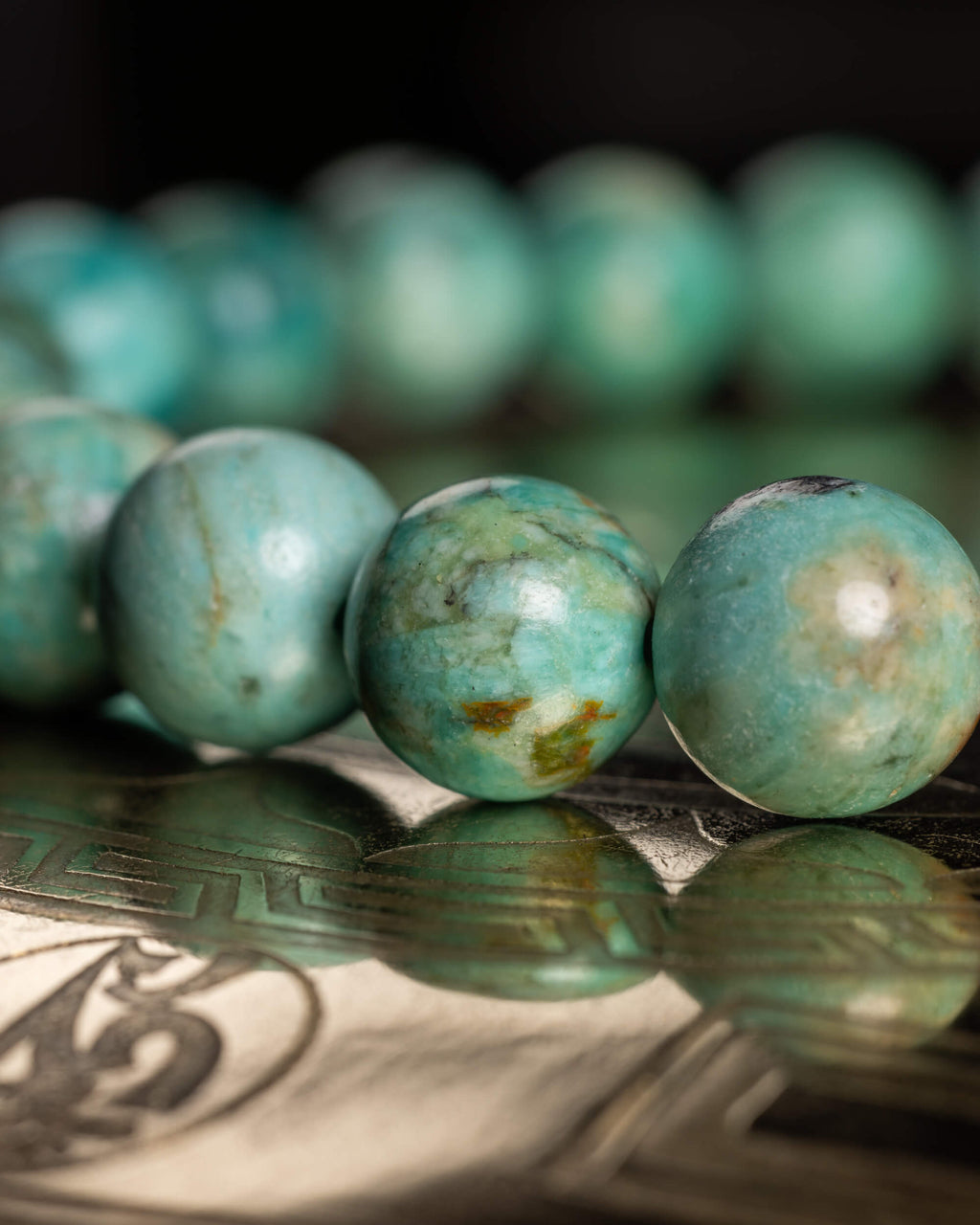 Pulsera de Turquesa Peruana en perspectiva, cuentas alineadas sobre soporte reflejante