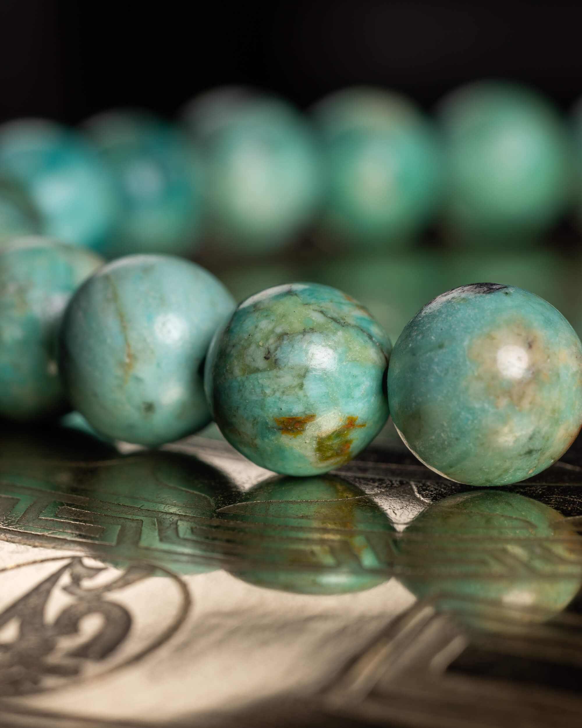 Pulsera de Turquesa Peruana en perspectiva, cuentas alineadas sobre soporte reflejante