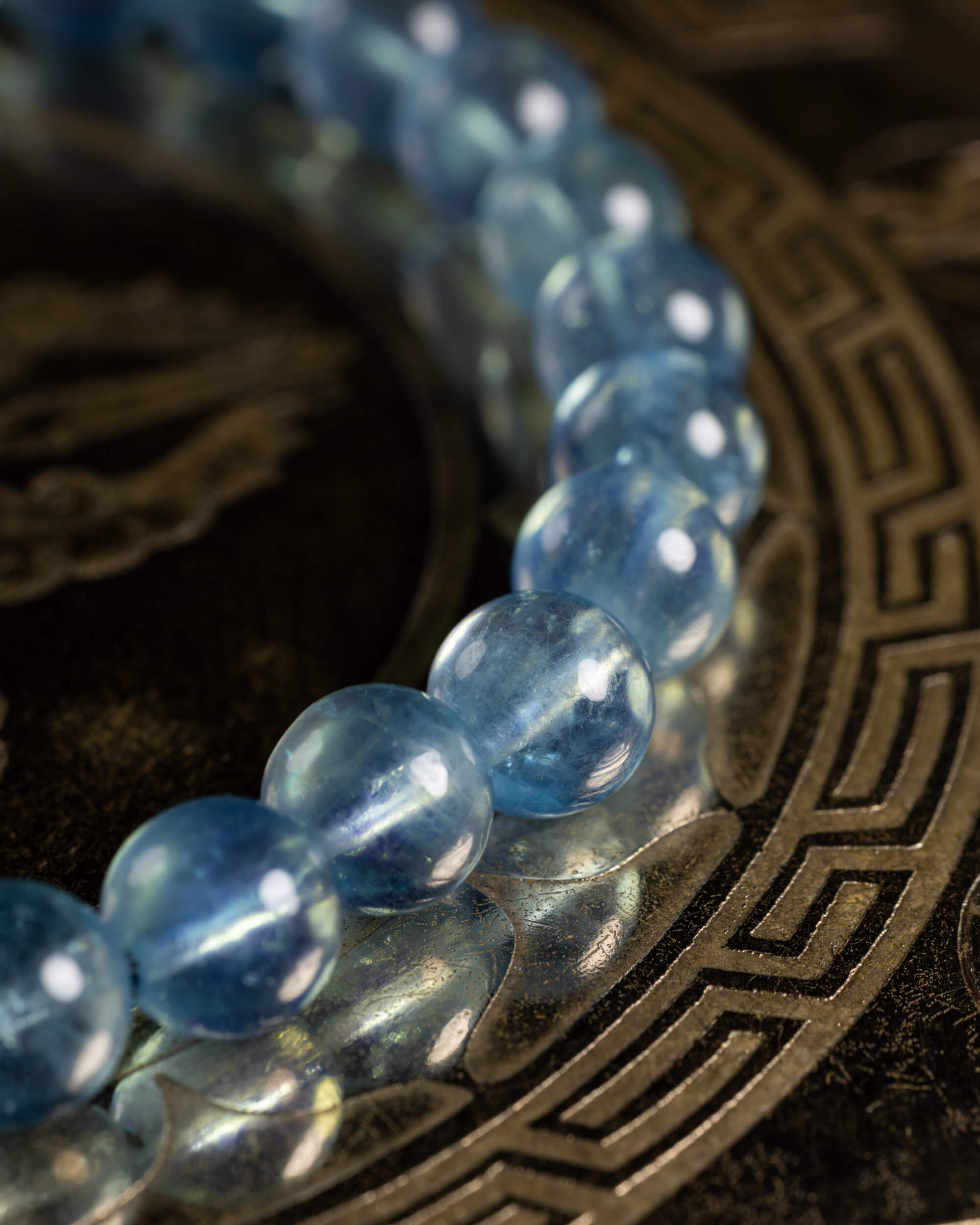 Pulsera de Aguamarina en curva cerrada, cuentas translúcidas sobre placa oscura