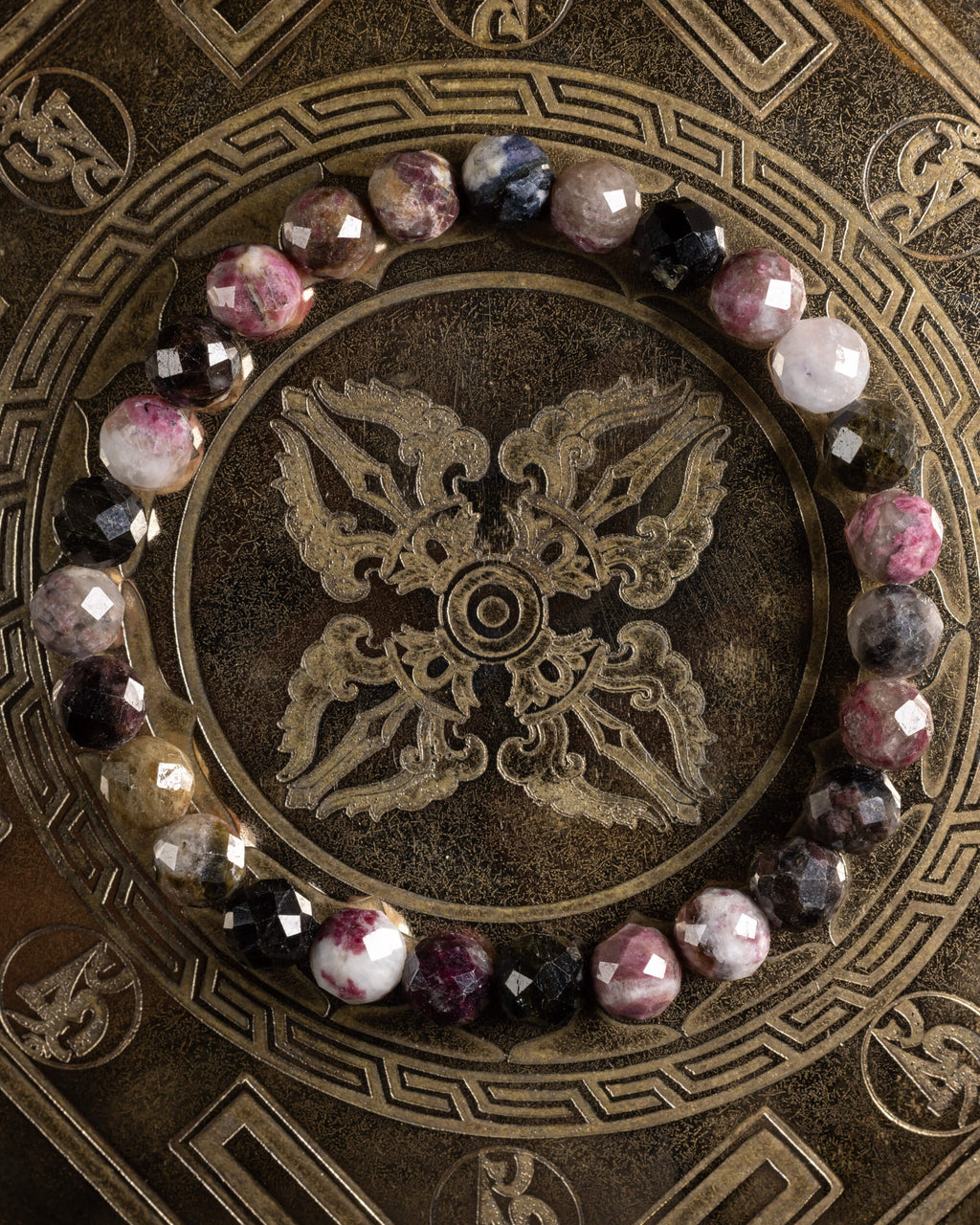 Pulsera de Turmalina Multicolor facetada, pieza completa en círculo sobre placa grabada