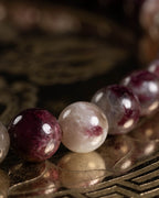 Detalle macro de cuentas de Turmalina Rubelita en vino y blanco, brillo suave