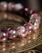 Pulsera de Turmalina Rubelita en curva, cuentas vino y blanco sobre placa oscura