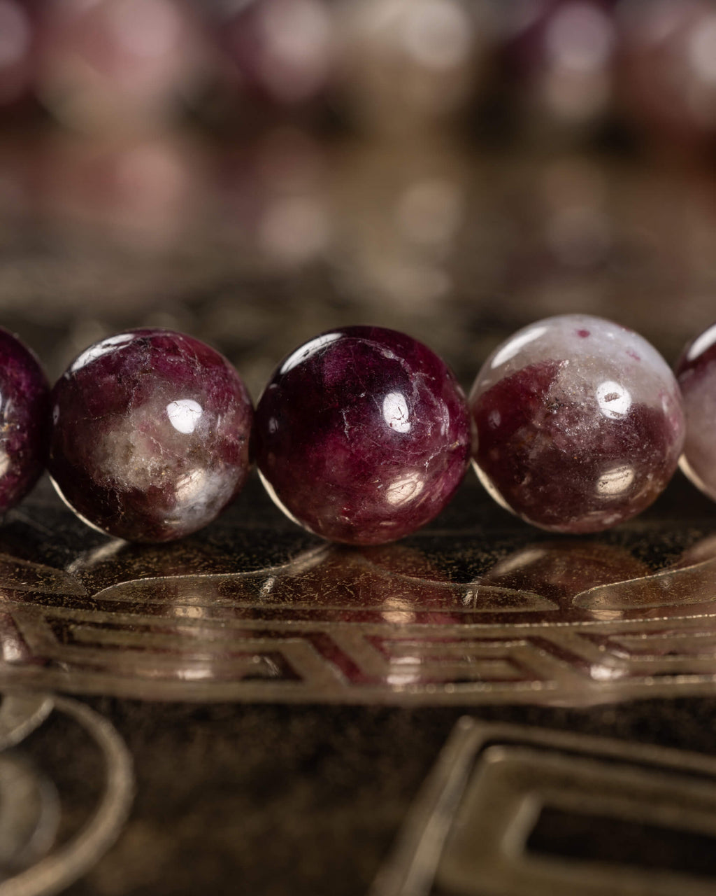 Detalle macro de cuentas de Turmalina Rubelita en tonos vino intenso y blanco