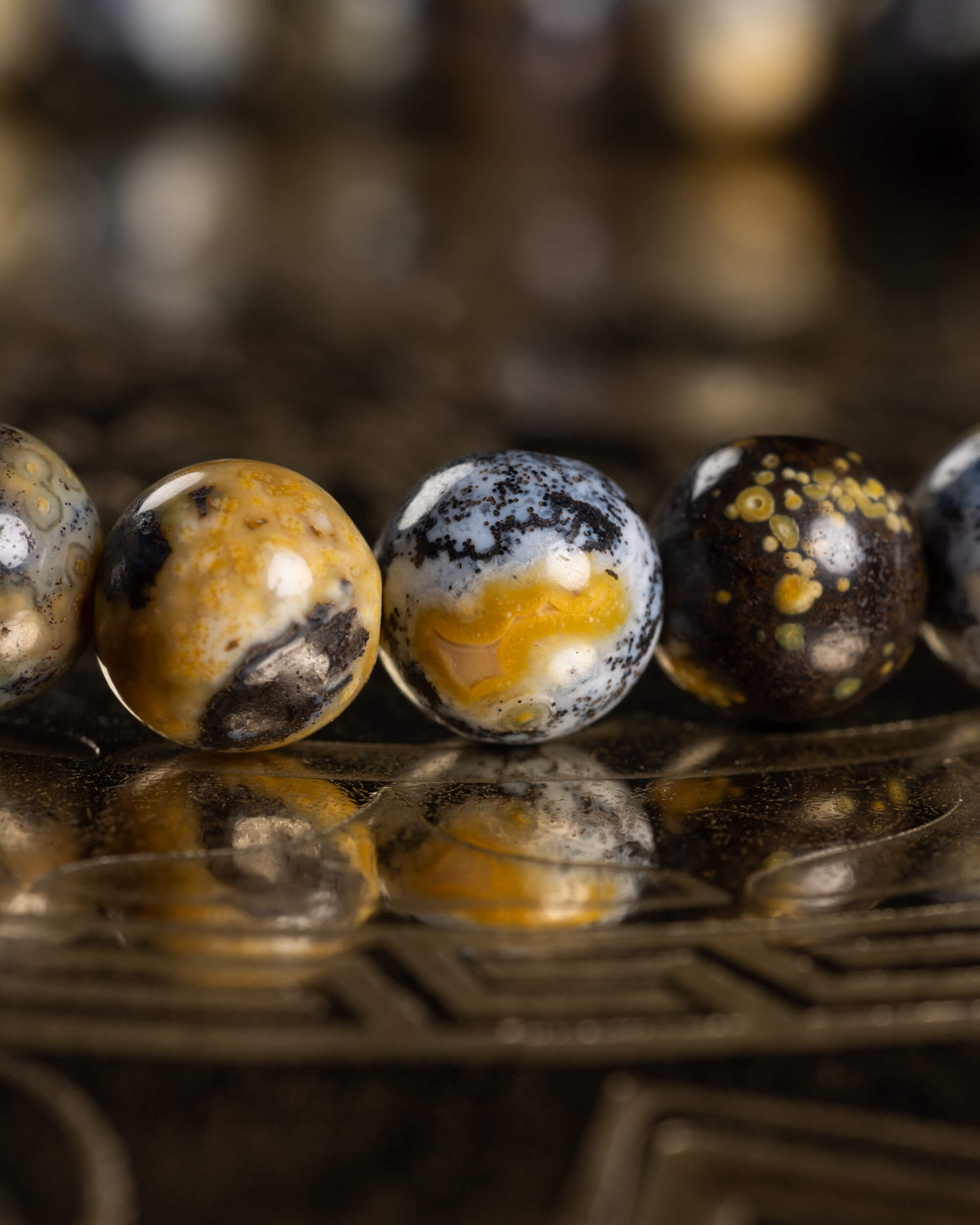 Detalle macro de cuentas de Jaspe Oceánico Amarillo con vetas negras y amarillas
