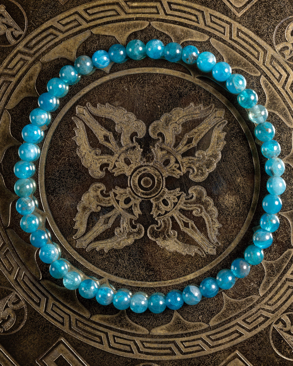 Pulsera de Apatita Azul de 4 mm, pieza completa sobre bandeja metálica grabada