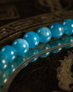 Pulsera de Apatita Azul en ángulo bajo, cuentas alineadas sobre bandeja metálica